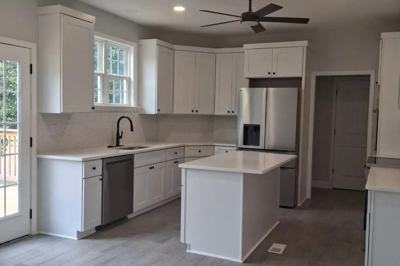 Finished kitchen with white cabinets, an island and new flooring